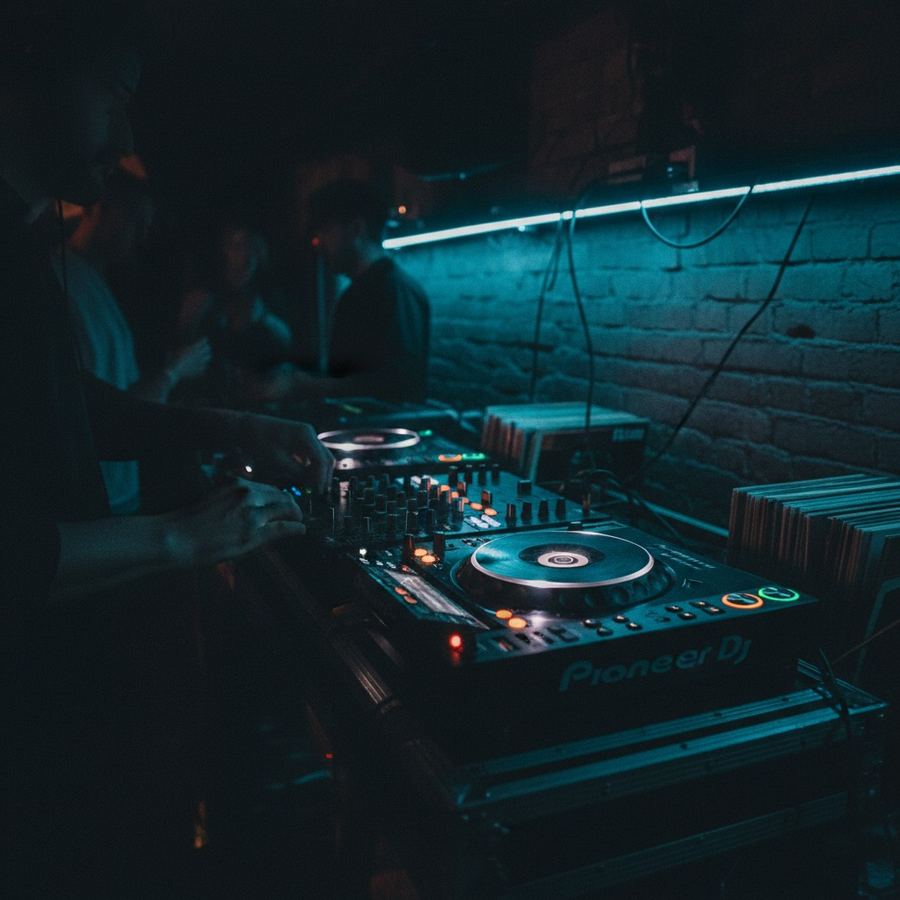 Two turntables with a mixer between them, vinyl records visible on both platters
